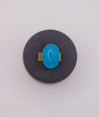 Anillo artesanal hecho a mano en resina UV de color azul cielo con base ajustable en acero inoxidable. Joyería artesanal inspirada en la cultura colombiana.