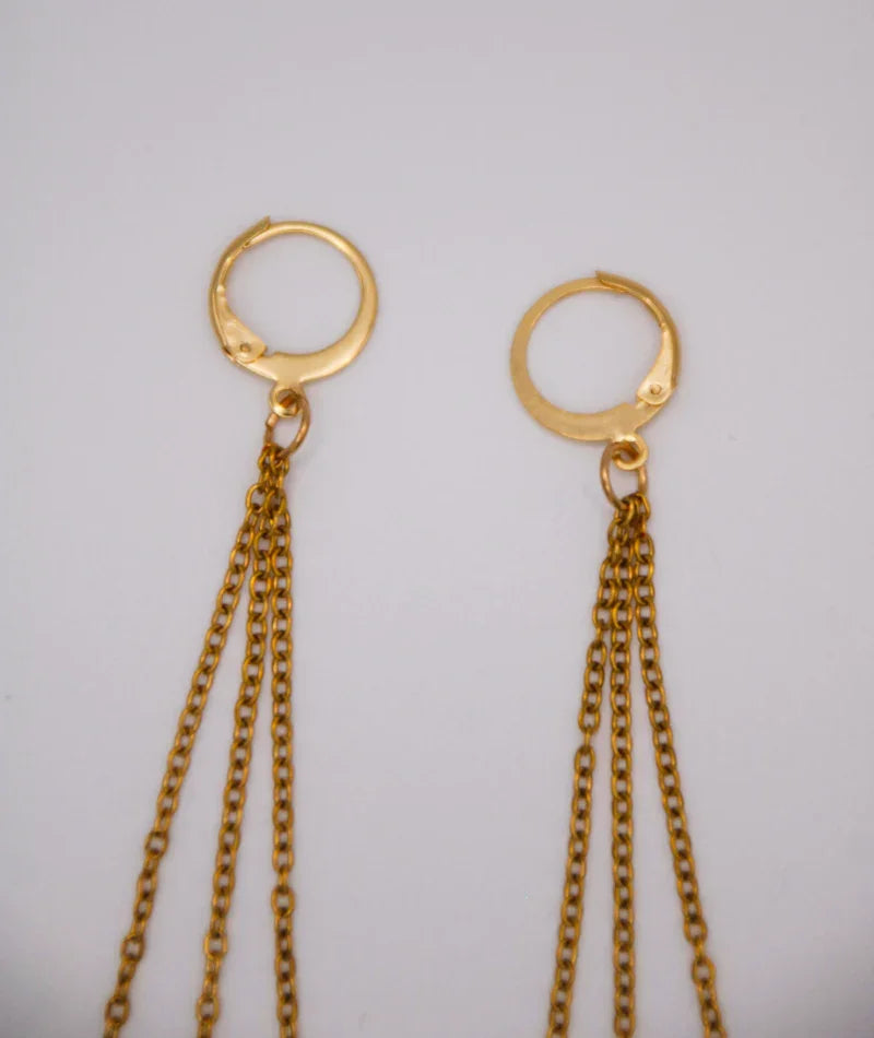 Aretes dorados con cadenas largas, joyería artesanal inspirada en Colombia