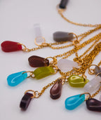 Collar artesanal con piedras coloridas en forma de gota y cadena dorada, inspirado en la cultura colombiana