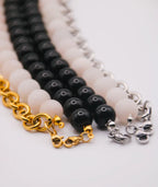 Collares intercambiables de cuentas negras y blancas, de cadenas de acero inoxidable dorado y plateado. Joyería artesanal inspirada en la cultura colombiana.