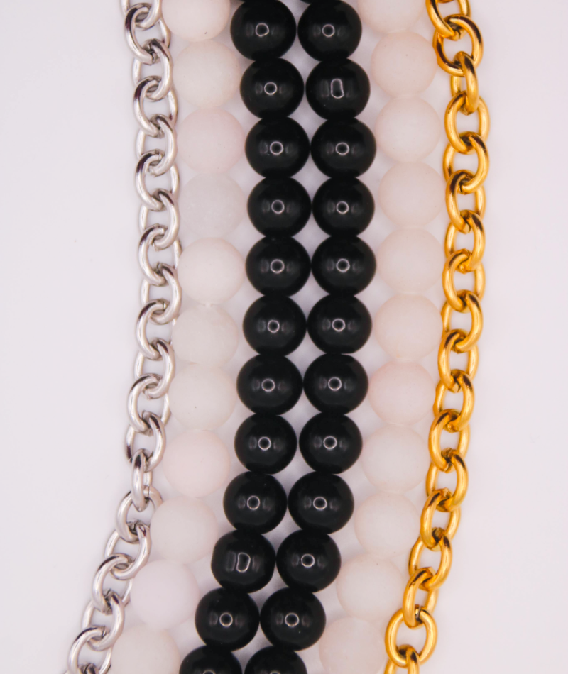 Collares intercambiables de cuentas negras y blancas, de cadenas de acero inoxidable dorado y plateado. Joyería artesanal inspirada en la cultura colombiana.