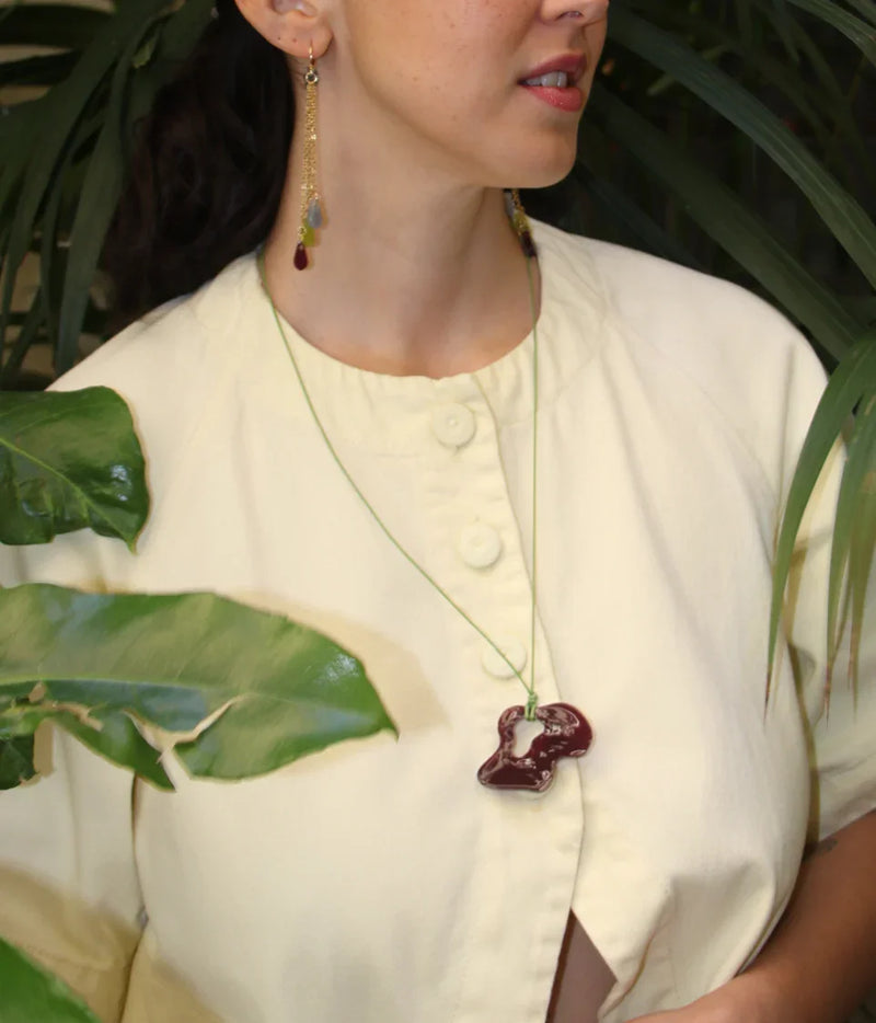 Collar artesanal con colgante de cerámica roja y aretes largos con piedras, inspiración colombiana