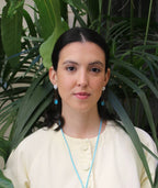 Mujer con aretes artesanales azules y collar de cuerda, joyería inspirada en cultura colombiana