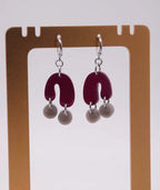 Pendientes artesanales con forma de U en rojo vino y perlas grises, accesorios inspirados en la cultura colombiana