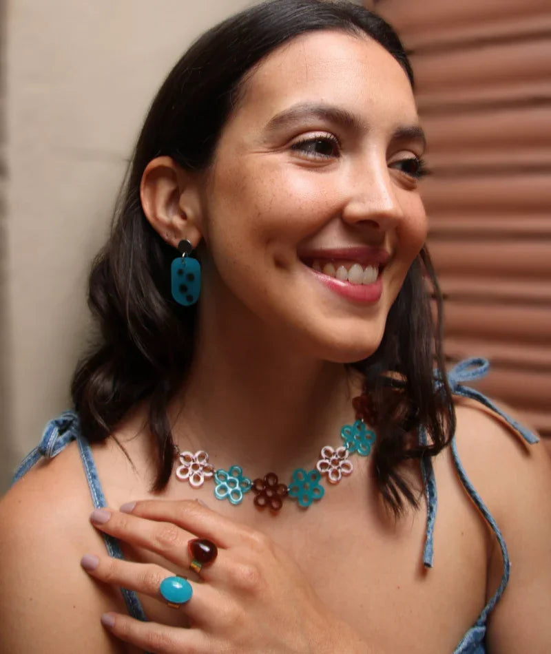 Collar y aretes artesanales con flores en tonos turquesa y marrón, joyería inspirada en Colombia
