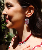 Pendientes artesanales con diseño de lunares rosados y collar de cuentas rojas, joyería inspirada en Colombia