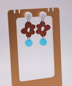 Pendientes artesanales con flor marrón y círculo azul, accesorios inspirados en cultura colombiana